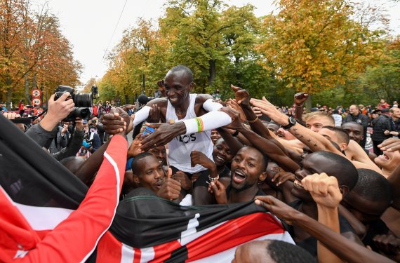 Behind the finish line, Eliud Kipchoge celebrates with his team.