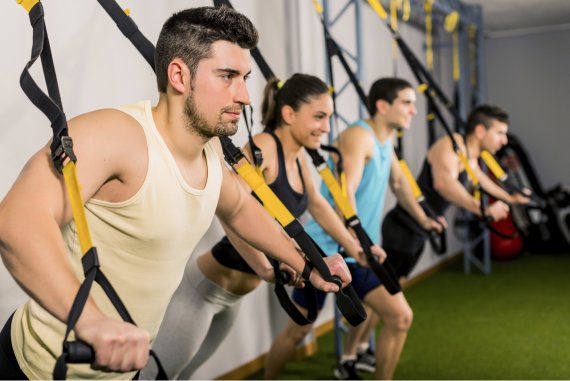 TRX Training in der Gruppe Eine Gruppe von Sportlern beim TRX Training