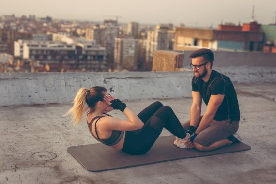 Training mit Trainingspartner Ein Paar macht draußen zusammen Sit ups