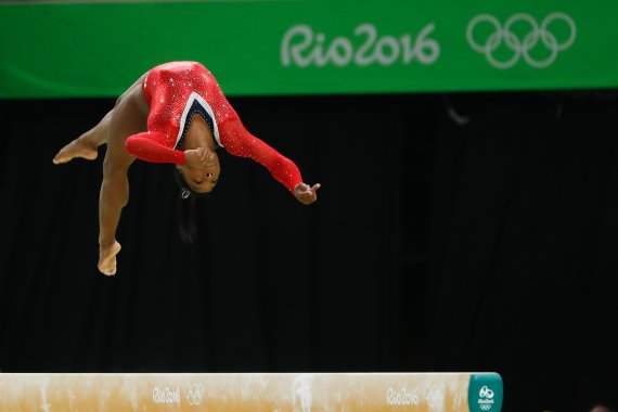 Simone Biles im Flug auf dem Schwebebalken: