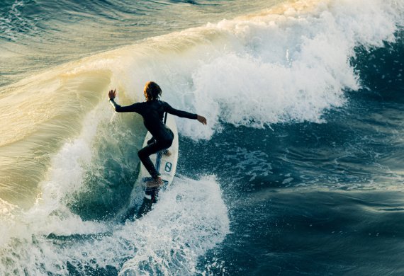 Surferin fährt auf eine Welle zu
