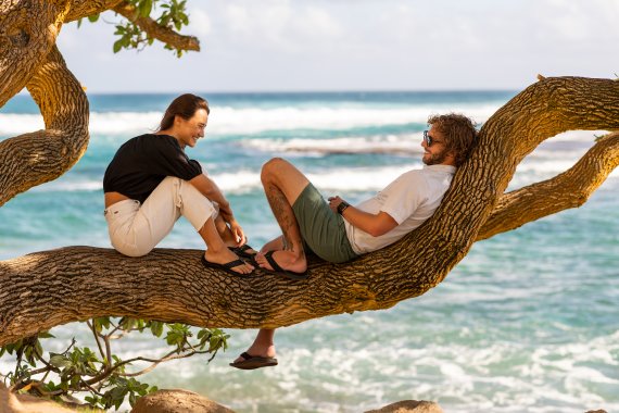 Entspannt auf dem Baum über dem Meer Paar sitzt auf dem Baum