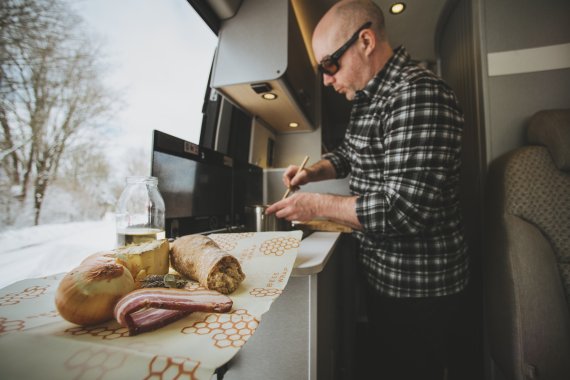 Kieran Creevy cocinando en la autocaravana