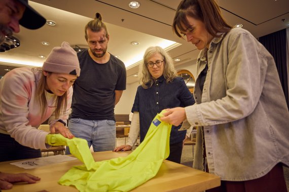 Mehrere Personen begutachten Textilwaren