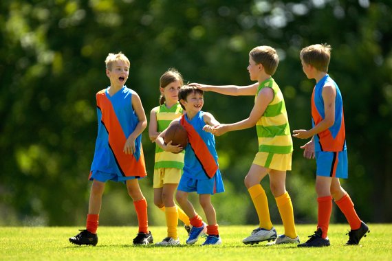 mb-151123-ThinkstockPhotos-85322687 Eine Gruppe Kinder mit einem Football.