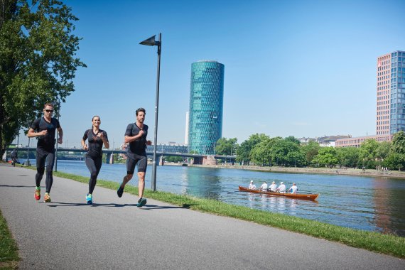 mb-151124-RUNNING Zwei Männer und eine Frau joggen in muskelstimulierenden Anzügen von Antelope am Mainufer.