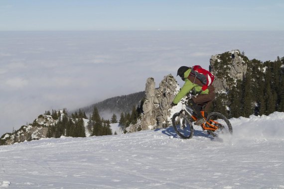 mb-lines_scheefraesn Ein Biker fährt auf Schnee den Berg hinunter