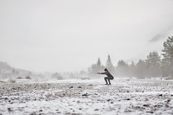 mb-freeletics_running Frau macht Übungen auf einem schneebedeckten Feld.