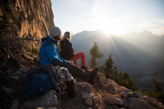mb-jack-wolfskin Two mountain climbers look towards the sunset.