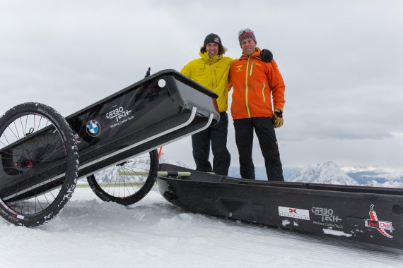 Stefan Glowacz und Robert Japser (orange) zeigen auf der Zugspitze, wie man die Carbon-Pulka als Rikscha verwenden kann.