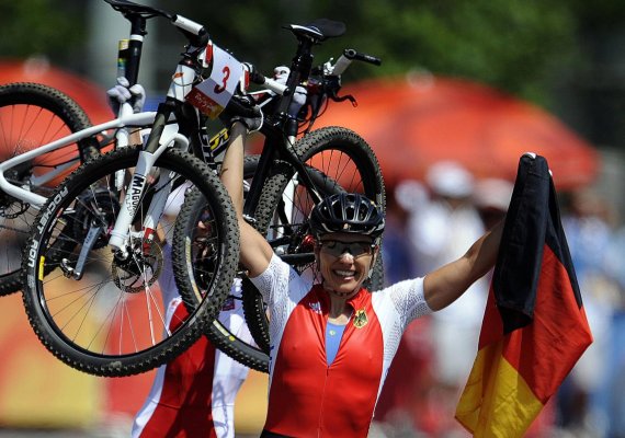 mb-160727-imago12478354h Sieg bei Olympia in Peking 2008: Direkt nach dem Gewinn der Goldmedaille stemmt Sabine Spitz vor Freude ihr Mountainbike in die Höhe.