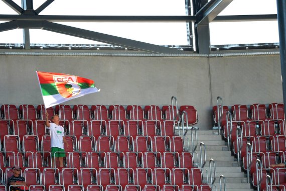 mb-160829-fan-augsburg-wolfsburg-bundesliga A lonely, young supporter of FC Augsburg waves his flag in the stadium of VfL Wolfsburg.