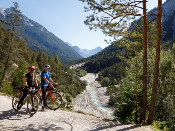 Zwei Fahrradfahrer sind mit dem Gravelbike auf dem Schotter unterwegs