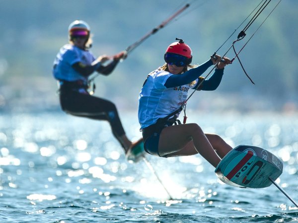 Two kitefoilers float over the water. 