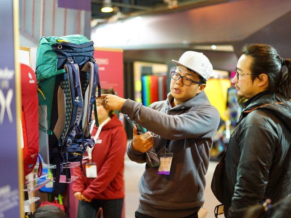 Two men inspect a rucksack.