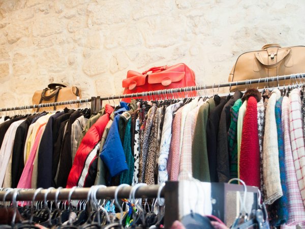 A row of clothes hangs on a clothes rack. 