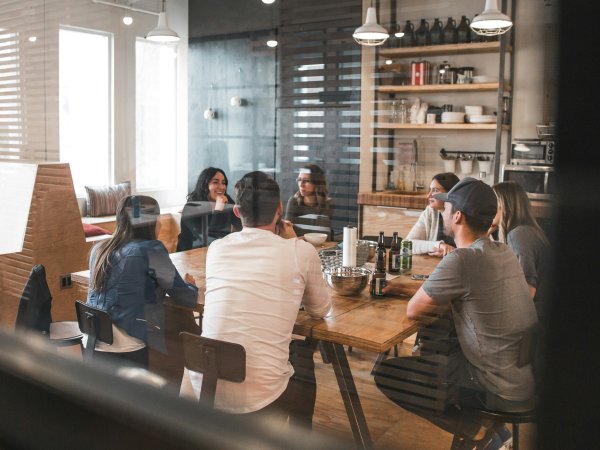 A group of young people talk to each other in an office with a start-up vibe
