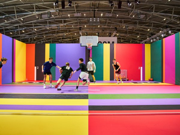 Junge Leute spielen auf buntem Basketballplatz