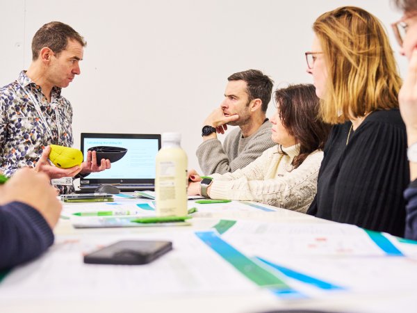 People sit around a table and talk about a product.