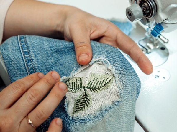 Jeans with a hole are sewn with patches