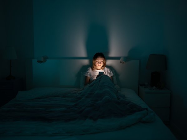 Frau nachts im Bett am Handy