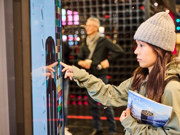 Woman at ISPO 2024 taps on screen