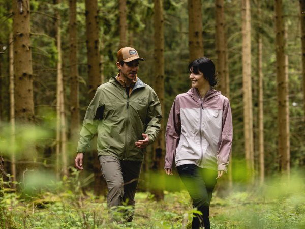Woman and man with outdoor jackets from Marmot in the forest
