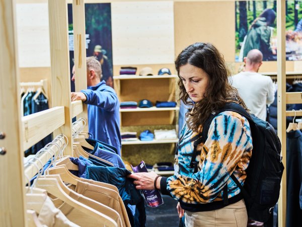 Person auf der ISPO 2024 schaut sich nachhaltigke Produkte an