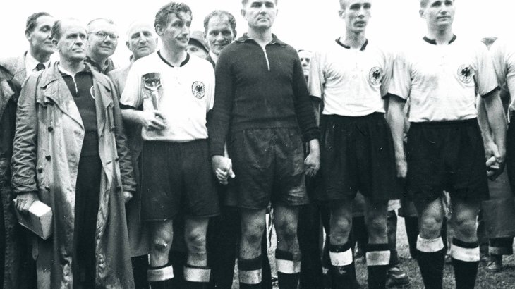 Quelle: Imago WM 1954: Den ersten WM-Titel schaffte die deutsche Nationalmannschaft noch im traditionellen Look: Fritz Walter (mit Pokal) führte sein Team in weißen Trikots, schwarzen Hosen und schwarzen Stutzen aufs Feld. Zum DFB-Team gehörte auch der Zeugwart Adolf Dassler, der Gründer von Adidas, der im Finale bei Regenwetter Schraubstollen an die Schuhe anbrachte.