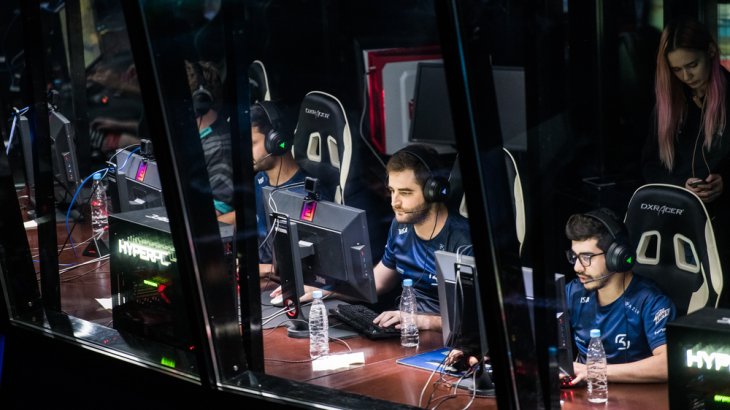 eSport Spieler befinden sich in einem Wettkampf und schauen konzentriert auf ihre Monitore.