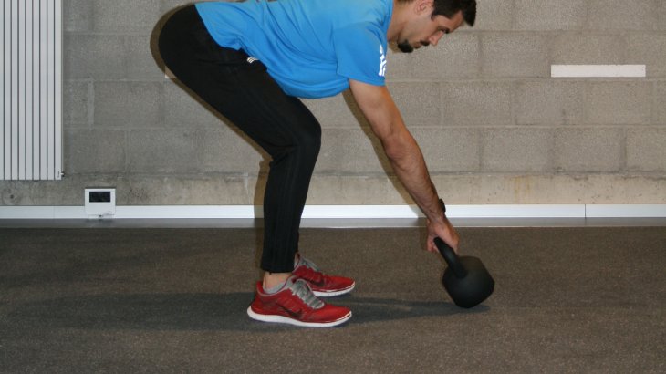 Bend forward from the hip and grab the ball, tilting it up. Pulling the shoulder blades together brings the ball into the correct distance from the body. And also, tense up your stomach like you're expecting a punch.
