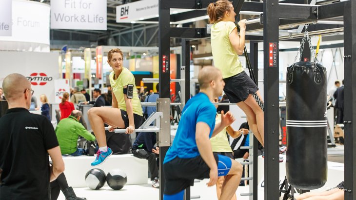 mb-151118-ISPO MUNICH 2015_jf_1216 Models machen Übungen an ausgestellten Geräten.