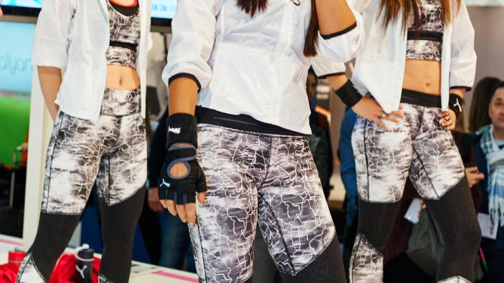 mb-151129-ISPO MUNICH 2015_jf_0401 Hostessen präsentieren ein Sportprogramm auf der Bühne.