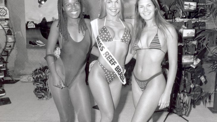 mb-151129-ispo96S_02-1 Drei Models in Bademode, die mittlere trägt eine Schärpe mit den Worten "Miss Reef Brazil".