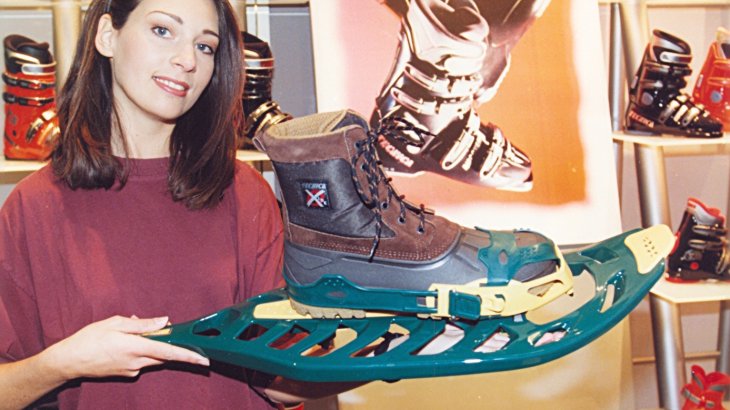 mb-151129-ispo97W_35-1 Eine Hostess präsentiert einen Schneeschuh.