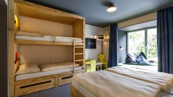 Ein Stockbett und 2 Doppelbetten, viel Stauraum und eine gemütliche Chill-Ecke. Die Aufteilung der Mehrbettzimmer im moun10 ist gut durchdacht und auf Outdoor-Sportler ausgelegt.