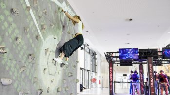 Besucherin an der digitalisierten Kletterwand