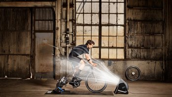 Sportler auf Wahoo KICKR Rollentrainer mit Headwind