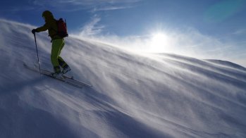 Karl with the jacket in rough conditions on the way to the mountain peak, where about 60 km/h strong wind blew hard snow into his face.