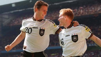 1996 gewann Deutschland die Europameisterschaft in England. Oliver Bierhoff (l.) schoss Deutschland in der 95. Minute mit einem Golden Goal zum Titel. Matthias Sammer wurde zum Spieler des Turniers gewählt. Die deutschen Farben wurden dezent im Kragen, den Bündchen und den drei Weltmeistersternen aufgenommen.