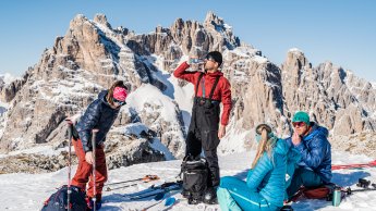 Personen pausieren bei einer Skitour auf einem Berg