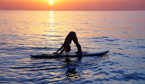SUP-Yoga promotes concentration and balance, since the exercises are carried out on the water on a surfboard.