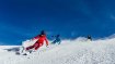 Three skiers ski on the slopes