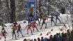 Biathleten fahren einen Berg hinauf.
