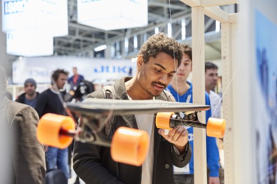 Ein Mann begutachtet ein Skateboard