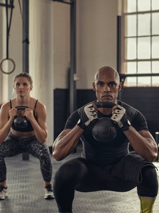 Zwei Personen trainieren mit der Kettlebell