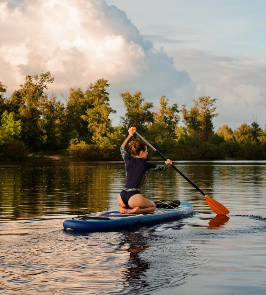 Weltmeisterin Sonni Hönscheid fährt mit Stand Up Paddle Board bei Sonnenuntergang