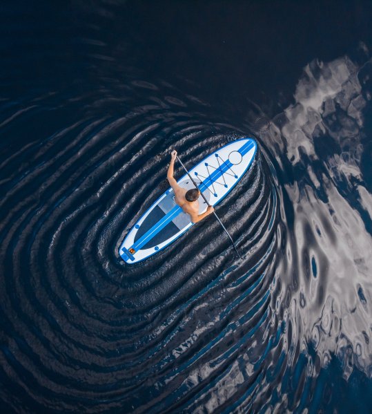 Mit dem Stand Up Paddle Board über das Gewässer 