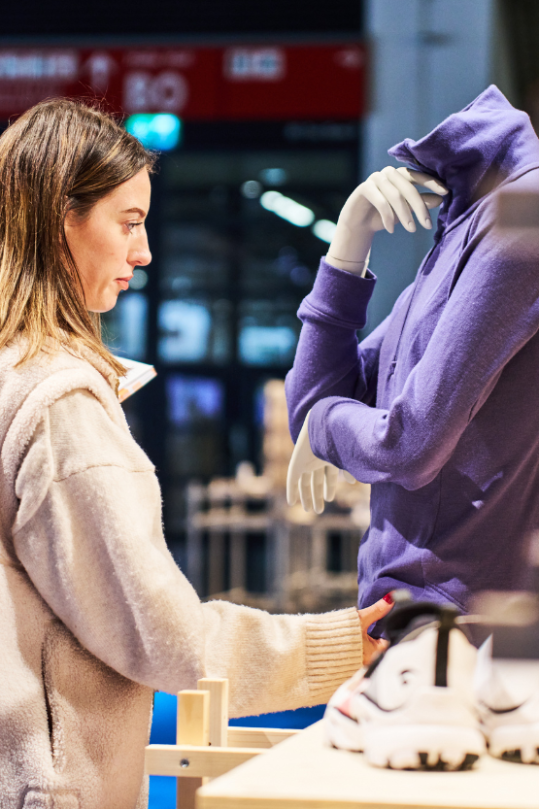 Retailerin greift Jacke auf der ISPO Award Ausstellung an