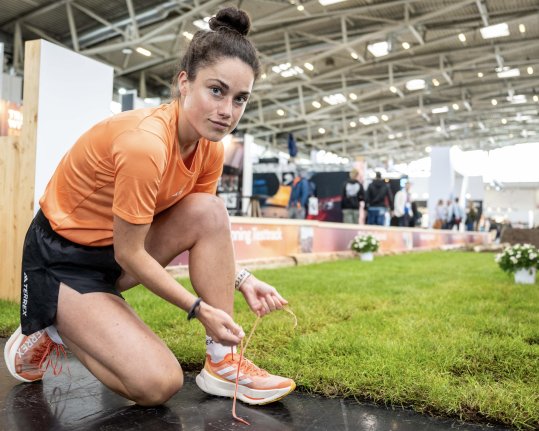 Trailrunnerin Kimi Schreiber bindet sich die Schuhe